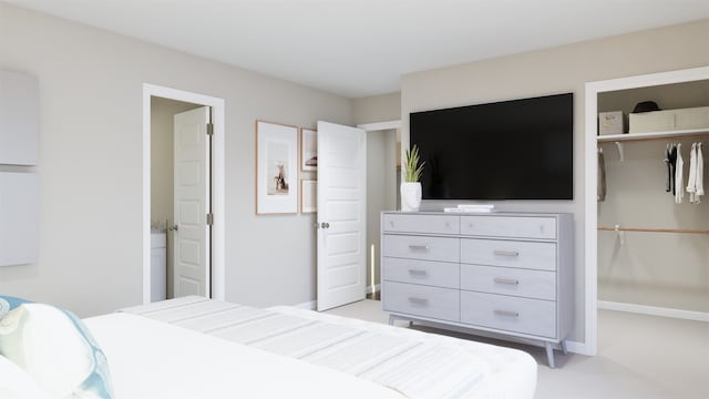 bedroom with baseboards, light carpet, a closet, and a spacious closet