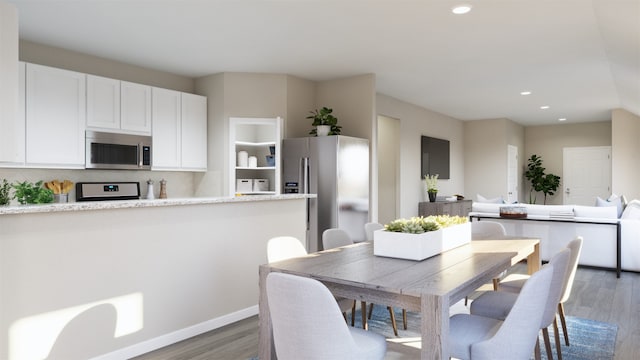 dining space with recessed lighting, baseboards, and wood finished floors