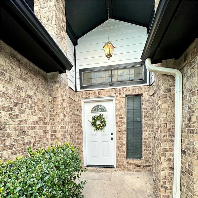 view of exterior entry featuring brick siding