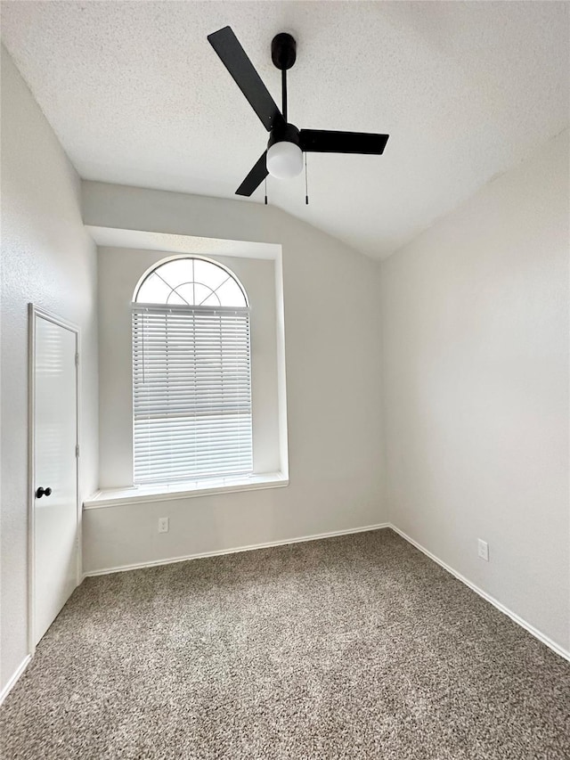 carpeted spare room with baseboards, a ceiling fan, and a textured ceiling