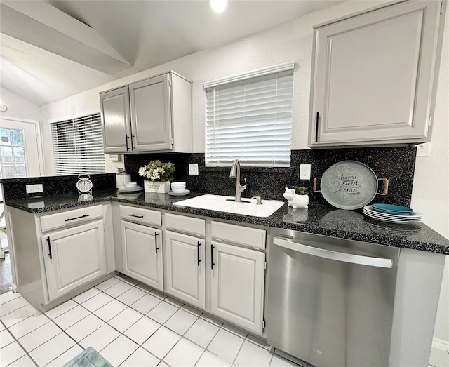 kitchen featuring a sink, dishwasher, a peninsula, tasteful backsplash, and vaulted ceiling