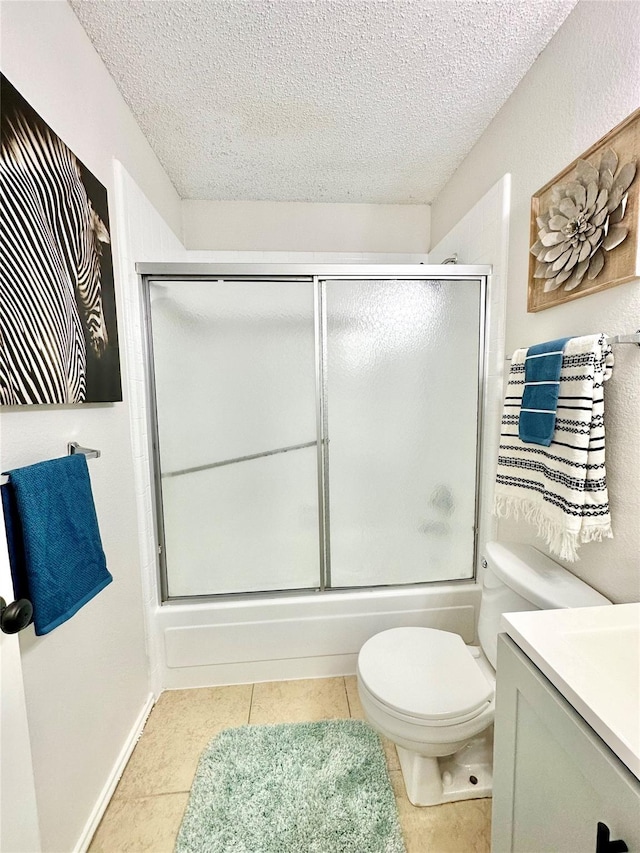 bathroom with a textured ceiling, tile patterned floors, vanity, toilet, and enclosed tub / shower combo