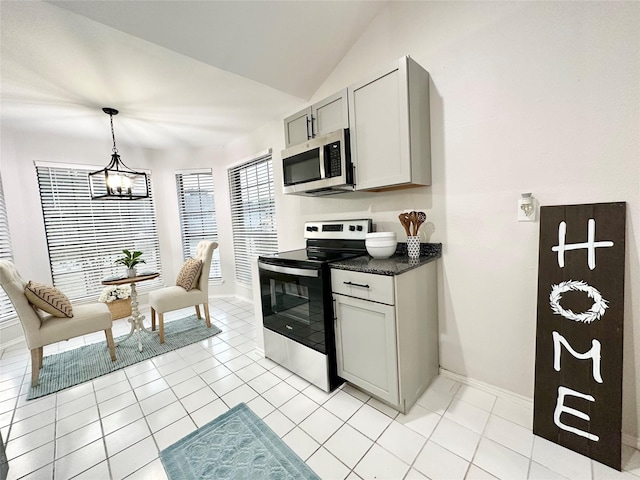 kitchen featuring baseboards, light tile patterned floors, lofted ceiling, and stainless steel appliances