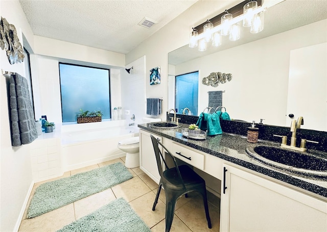 bathroom with double vanity, a bathtub, visible vents, and a sink