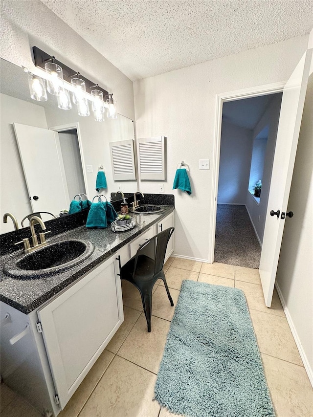 full bathroom with a sink, tile patterned floors, double vanity, and a textured ceiling