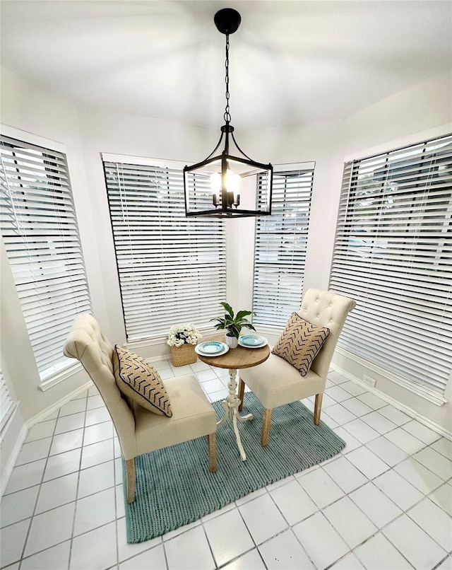 dining room with baseboards, breakfast area, tile patterned floors, and a chandelier