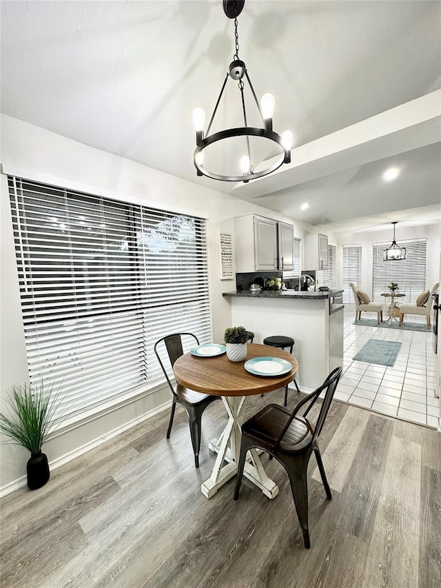 dining space featuring recessed lighting, baseboards, a notable chandelier, and light wood-style floors