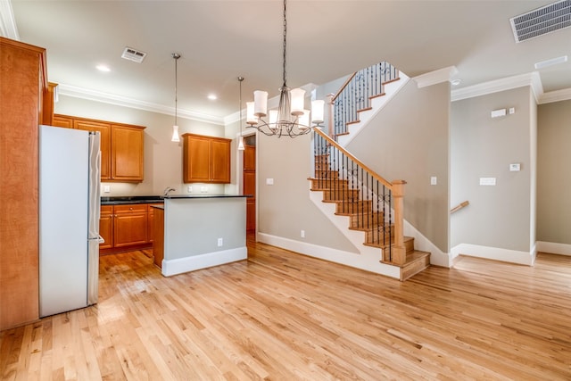 kitchen featuring freestanding refrigerator, visible vents, ornamental molding, and light wood-type flooring