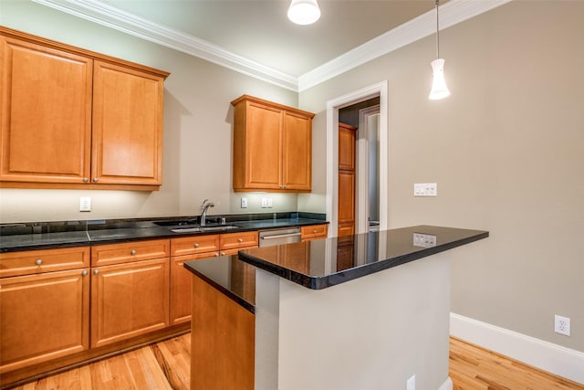 kitchen featuring ornamental molding, a kitchen island, light wood-type flooring, a sink, and decorative light fixtures