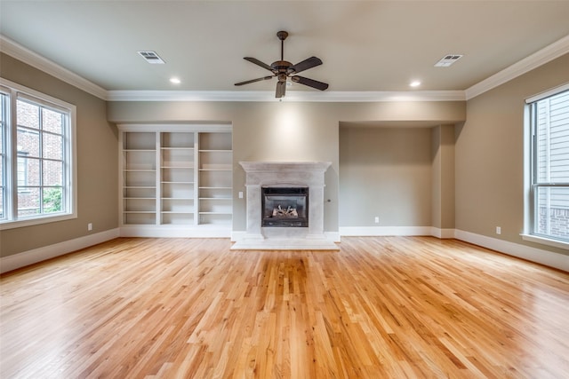 unfurnished living room featuring crown molding, baseboards, visible vents, and light wood-type flooring