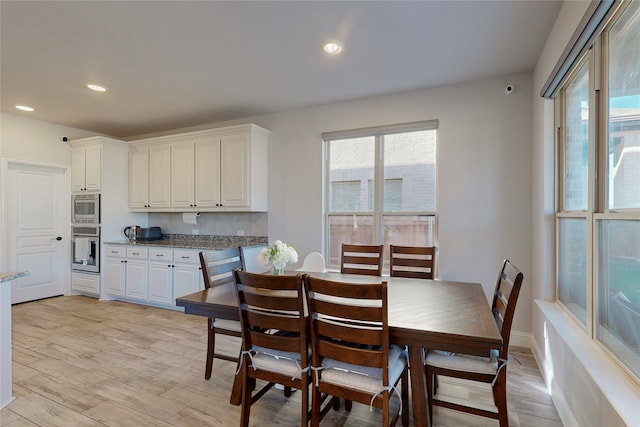 dining room with recessed lighting, baseboards, and light wood-style flooring