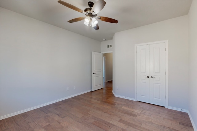unfurnished bedroom with light wood-style floors, baseboards, visible vents, and a closet