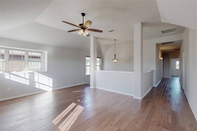 unfurnished living room featuring visible vents, ceiling fan, lofted ceiling, and a wealth of natural light