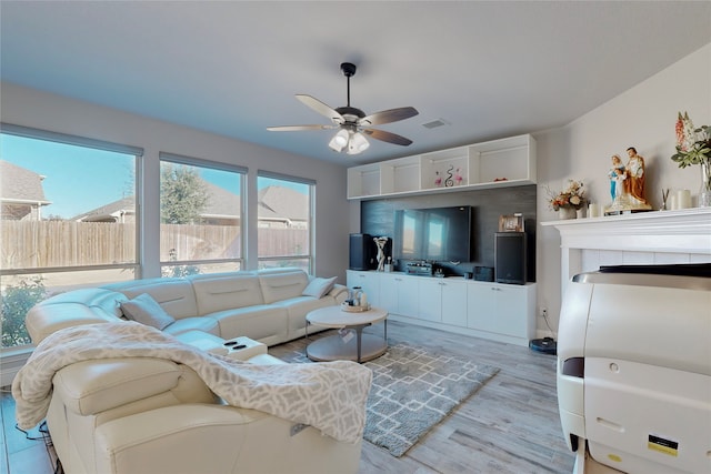 living area featuring a ceiling fan, wood finished floors, and visible vents