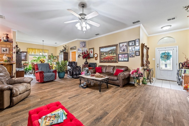 740 Bluebonnet Dr, Stephenville, TX 76401 - living room with visible vents, ornamental molding, ceiling fan with notable chandelier, and wood finished floors