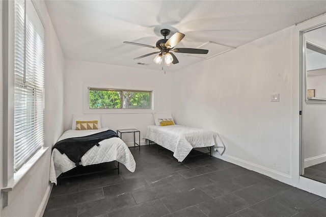 bedroom featuring baseboards, ceiling fan, and visible vents