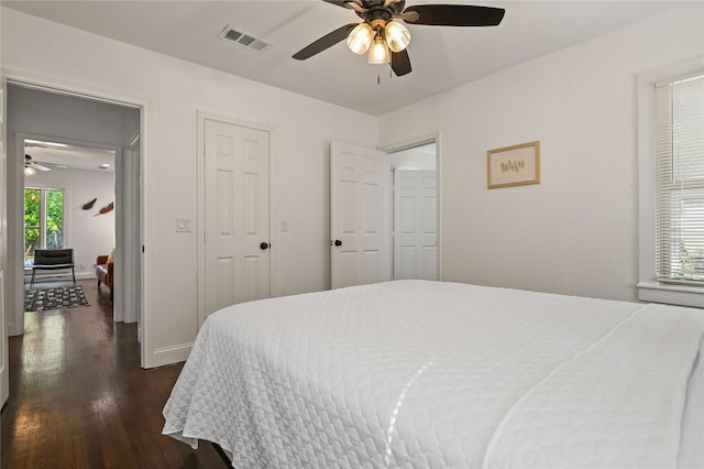 bedroom featuring baseboards, a ceiling fan, dark wood-style flooring, and visible vents