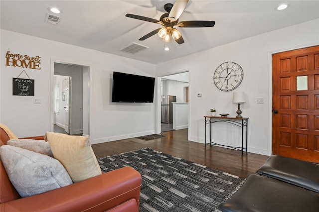 living room featuring visible vents, a ceiling fan, baseboards, and wood finished floors
