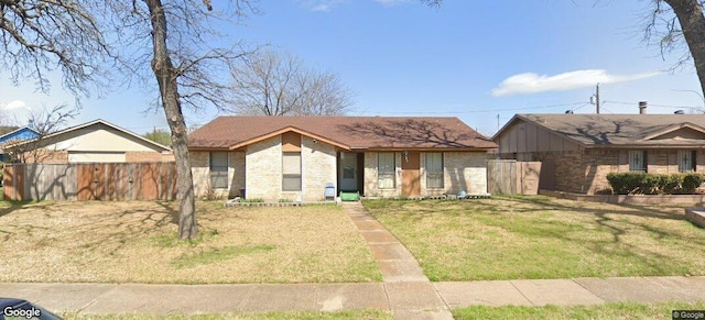 view of front of house with fence, brick siding, and a front yard