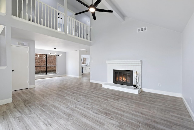 1308 Wheatfield Dr, Mesquite, TX 75149 - unfurnished living room featuring visible vents, a brick fireplace, beam ceiling, wood finished floors, and high vaulted ceiling