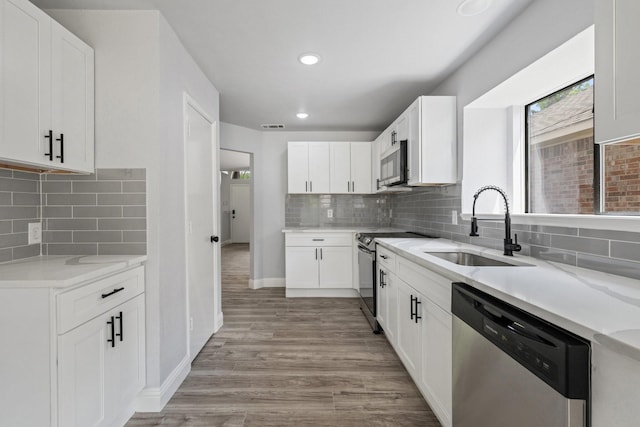 1308 Wheatfield Dr, Mesquite, TX 75149 - kitchen with light stone counters, a sink, light wood finished floors, stainless steel appliances, and backsplash