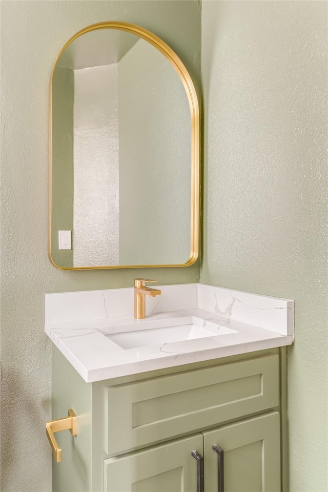 bathroom featuring a textured wall and vanity
