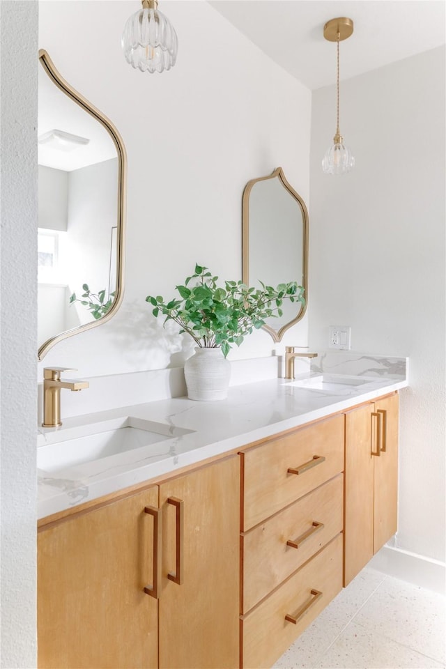 interior space with double vanity, a sink, and speckled floor