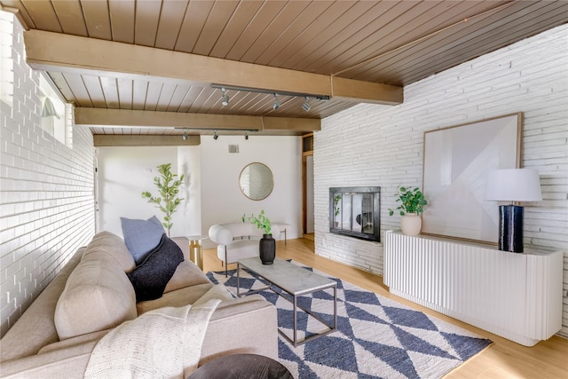 living room featuring wood finished floors, brick wall, beam ceiling, wood ceiling, and rail lighting