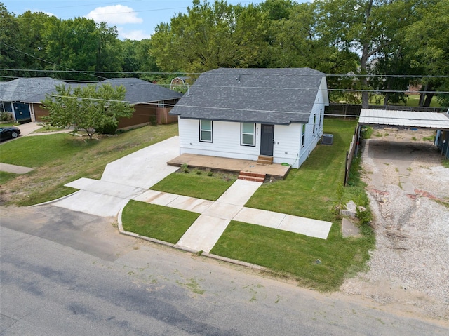 exterior space with fence, a front yard, a shingled roof, concrete driveway, and a carport