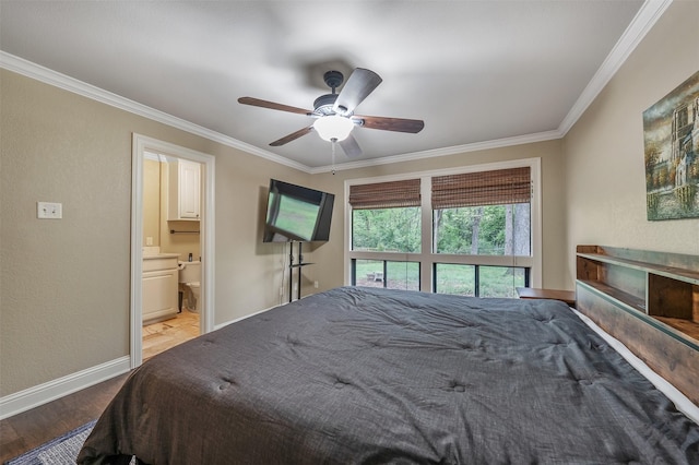 bedroom featuring crown molding, connected bathroom, baseboards, and wood finished floors