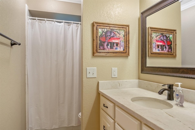 full bath featuring vanity, a textured wall, toilet, and curtained shower