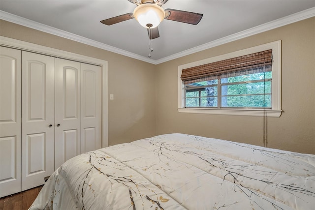 bedroom featuring crown molding, dark wood-style flooring, ceiling fan, and a closet