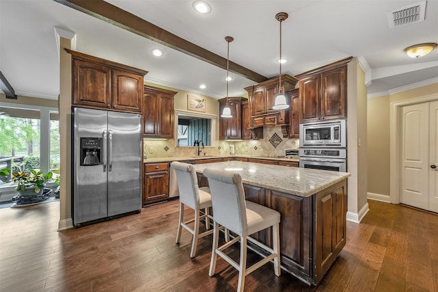 kitchen featuring visible vents, crown molding, a sink, and appliances with stainless steel finishes