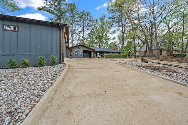 view of property exterior with board and batten siding and driveway