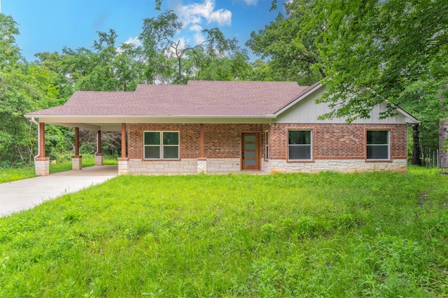 ranch-style home with a shingled roof, driveway, a front yard, and a carport