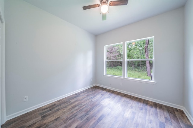 empty room with a ceiling fan, baseboards, and dark wood-type flooring