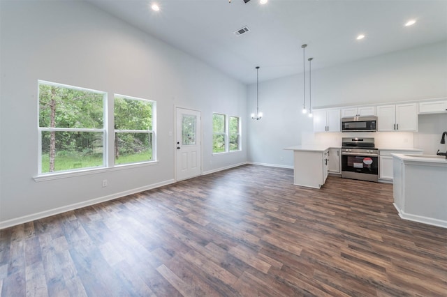 unfurnished living room featuring high vaulted ceiling, dark wood finished floors, recessed lighting, baseboards, and visible vents