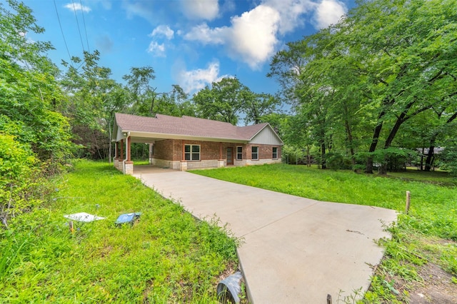 single story home with brick siding, driveway, a carport, and a front lawn
