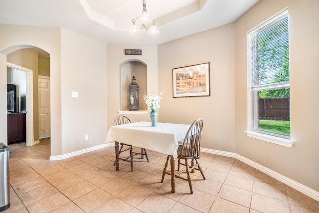 dining space featuring an inviting chandelier, arched walkways, plenty of natural light, and light tile patterned flooring
