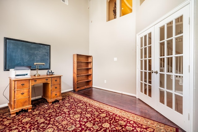 home office featuring baseboards, a high ceiling, french doors, and dark wood-style floors