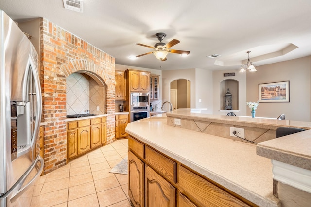 kitchen with visible vents, appliances with stainless steel finishes, arched walkways, light countertops, and light tile patterned flooring
