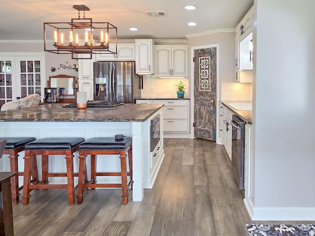 4512 Orchid St, Shreveport, LA 71105 - kitchen with stainless steel fridge with ice dispenser, ornamental molding, white cabinets, wood finished floors, and tasteful backsplash