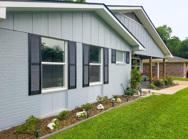 4512 Orchid St, Shreveport, LA 71105 - view of side of home featuring brick siding, a lawn, and board and batten siding