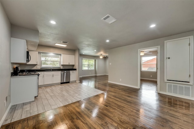 kitchen featuring dark countertops, stainless steel appliances, open floor plan, and visible vents