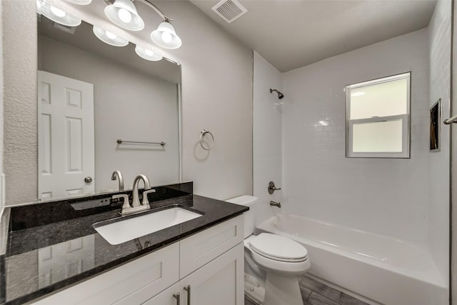 bathroom with vanity, toilet,  shower combination, and visible vents