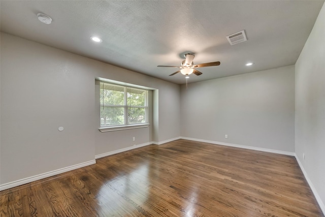 empty room with a ceiling fan, baseboards, recessed lighting, wood finished floors, and visible vents