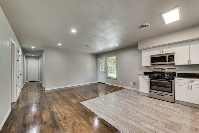 kitchen featuring stainless steel appliances, open floor plan, recessed lighting, wood finished floors, and visible vents