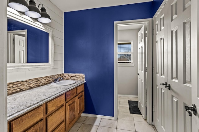 bathroom with baseboards, tile patterned flooring, and vanity