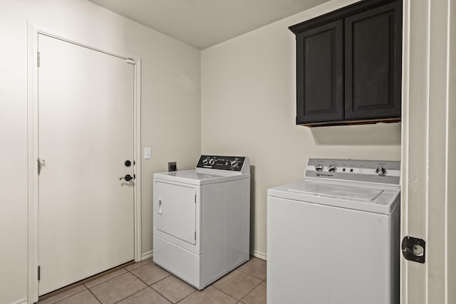 washroom with light tile patterned flooring, cabinet space, and washer and dryer