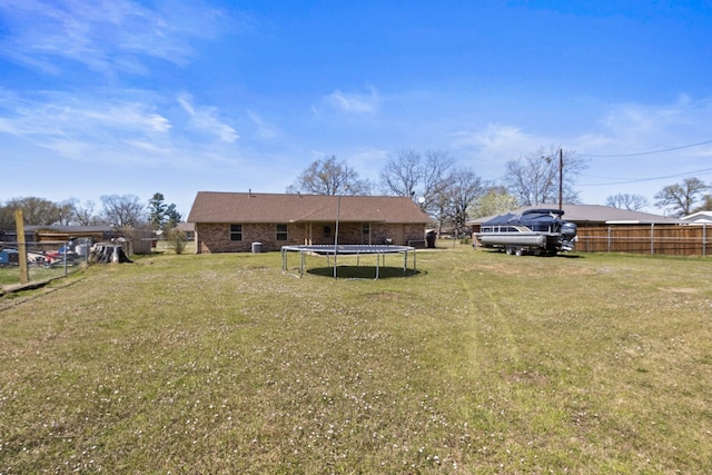 view of yard with fence and a trampoline